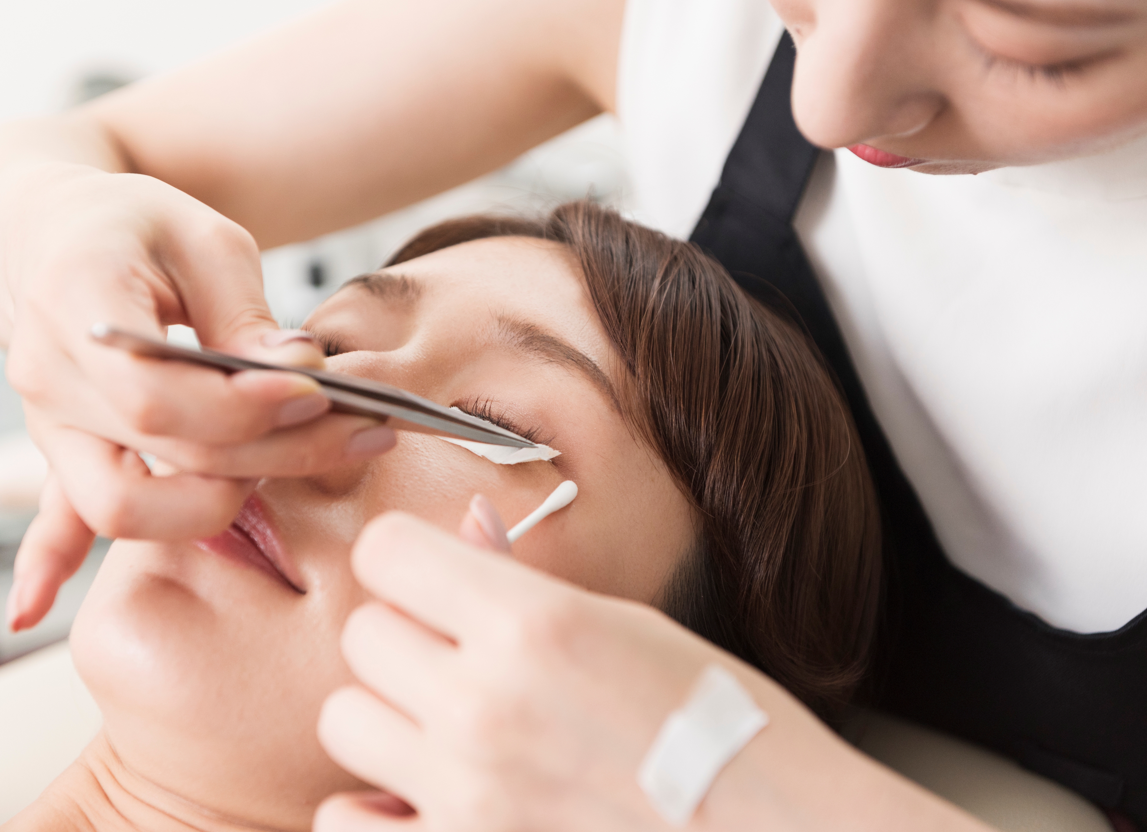 a cosmetologist putting eyelashes to customer 